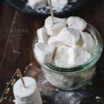 Ein Glas voller veganer Marshmallows auf einem Holzuntergrund