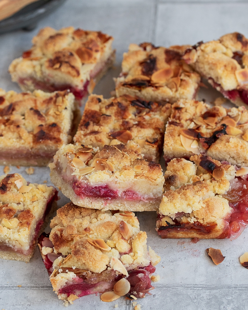 Viele Stücke Rhabarberkuchen auf einer Unterlage.