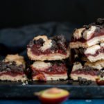 Several slices of streusel plum cake on a rectangular plate.