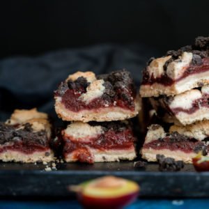 Several slices of streusel plum cake on a rectangular plate.