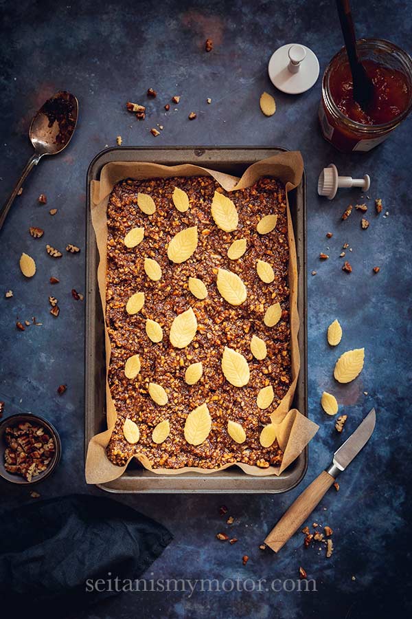 A tray of Nussecken (Caramel Nut Bars) on a blue background.