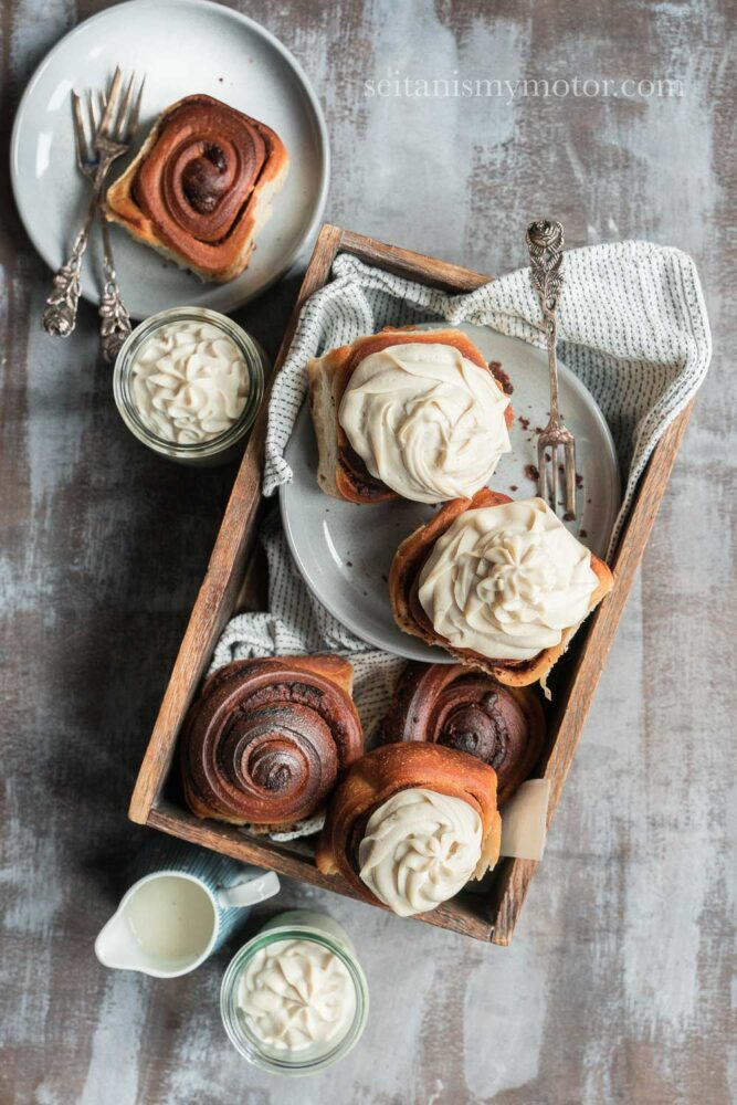 Picture of a wooden box with chocolate rolls inside. The chocolate rolls are decorated with whipped cream substitute.