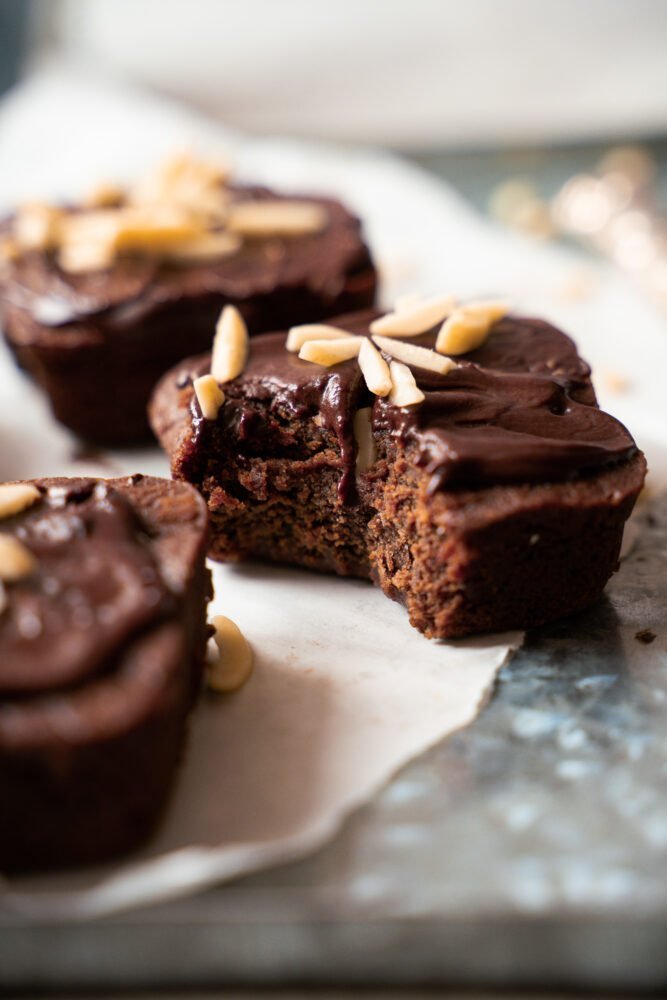 This picture shows three small batch chocolate brownies on a a piece of white parchment paper.