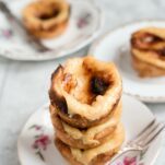 Threee vegan pasteis de natat stacked on top of each other.